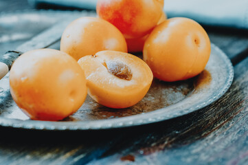 Yellow mirabelle plums in rustic metal dish