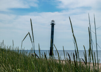 traditional summer landscape with sandy and pebbly promontory, green dune grass, abandoned sloping...