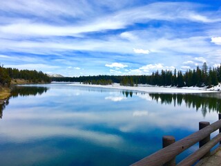 Reflections on a lake with blue skies and clouds