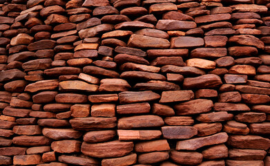 Close-up of a hand-packed red stone wall forming a barrier against danger