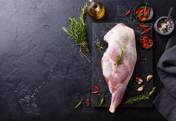 Raw lamb leg with spices and herbs on marble cutting board. Dark background. Copy space. Top view. - 369533335