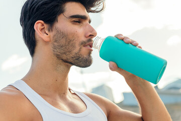 portrait of sportsman drinking water from a bottle