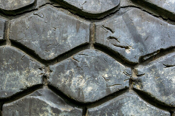 Old car tire surface. Damage of old tire. Closeup of crack and tear tire texture.