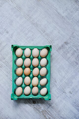 Raw eggs laying on the mint stand and wooden background