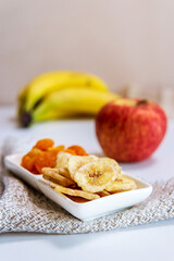 Healthy snacks dry bananas in a bowl. Dried fruits. vertical photo