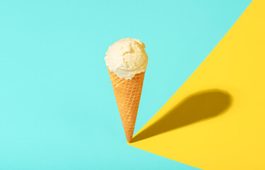Vanilla ice cream cone in bright light. Waffle cone ice cream on summer colors