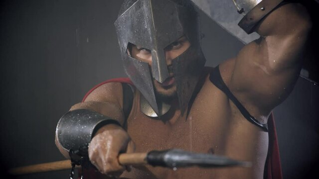 Spartan hiding from rain under shield.