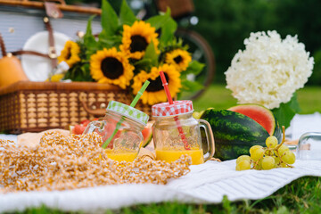 Summer picnic concept on sunny day with watermelon, fruit, bouquet hydrangea and sunflowers...