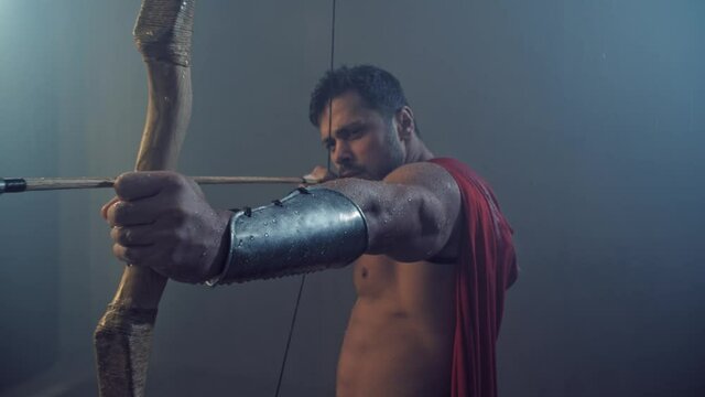 Wooden bow in hand of spartan hunter.