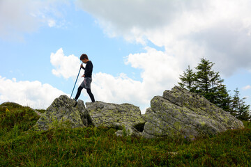 travel concept - little boy hiking boots in mountains. Little traveller at the top mountain. Hiking in mountains on summer.