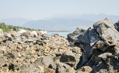 Fototapeta na wymiar Rocks of volcanic origin on the beach of the island of Lihada-Greece 