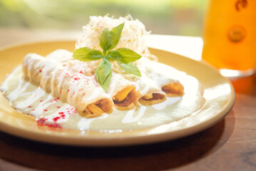 Traditional Mexican green enchiladas. Typical Mexican breakfast. Authentic Mexican enchiladas with creamy green sauce and melted cheese