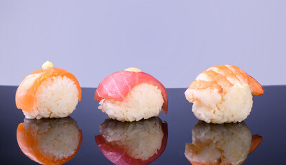 Three fresh and delicious sushi with shrimp, tuna, salmon. Sushi with reflection. Sushi close-up.