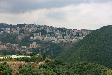 Fototapeta na wymiar Houses in the hills, Lebanon. Dense development of the coast. Lebanese Villages near the capital