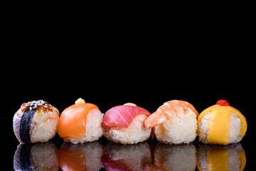 Beautiful and delicious, juicy set with cheese, eel, tuna, shrimp, salmon on a black background, with reflection. Delicious set dry close-up.