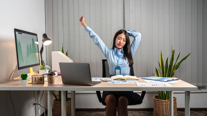 Young Asian Business woman stretching herself and relax while working hard