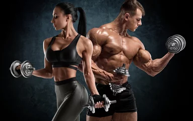 Fototapete Bestsellern Sport Sportliches Paartraining mit Kurzhanteln. Muskulöser Mann und Frau, die Muskeln zeigen