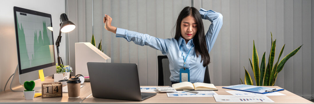 Young Asian Business woman stretching herself and relax while working hard