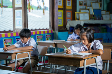 Asian elementary students in uniform studying together at classroom,Education,Student,People concept.