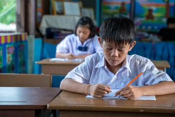 Asian elementary students in uniform studying together at classroom,Education,Student,People concept.