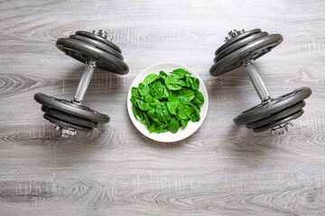 Set of weights and baby spinach on a plate