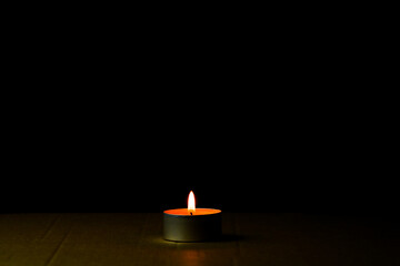 Lonely candle burning in the dark