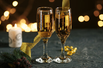 Ribbon, baubles and wine against Christmas lights.