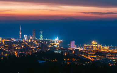Obraz premium Batumi, Adjara, Georgia. Aerial View Of Urban Cityscape At Sunset. Town At Evening Blue Hour time. City In Night Lights Illuminations