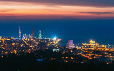 Fototapeta na wymiar Batumi, Adjara, Georgia. Aerial View Of Urban Cityscape At Sunset. Town At Evening Blue Hour time. City In Night Lights Illuminations
