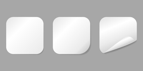 Set of vector white paper stickers with curled corners isolated on gray background.
