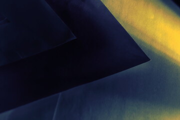 background with yellow beam, illuminating cobalt blue geometric shapes arranged symmetrically.