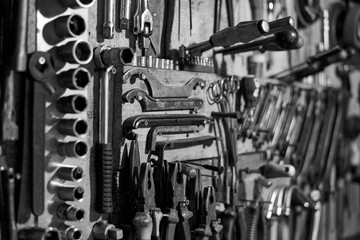 Fototapeta na wymiar Work tools on the garage wall, black and white photo.