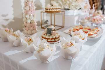 Candy bar at the banquet. Wedding table with sweets, cake, pastries, muffins, sugar treats. Event in the restaurant