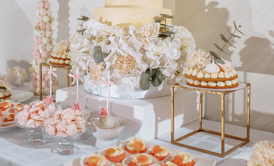Candy bar at the banquet. Wedding table with sweets, cake, pastries, muffins, sugar treats. Event in the restaurant