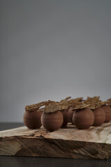 Nahaufnahme von frischen Pralinen mit Cracker auf Holzbrett mit dunklem Stein Tisch vor grauem Hintergrund