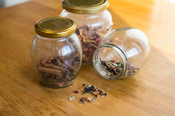 Glass jars with cinnamon and tea stand on a light wooden table
