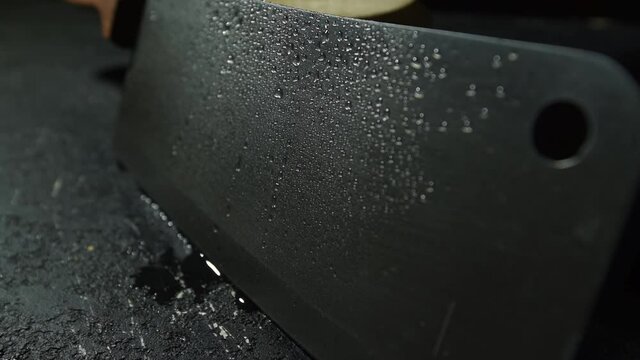 a kitchen knife in the cook's hand is sharpened in a special knife sharpener on the table.man sharpening knife