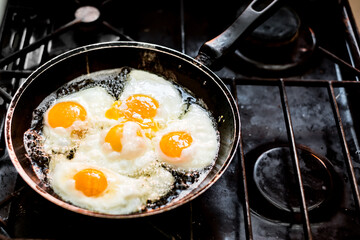 Fried eggs in the pan on the gas stove