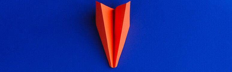 top view of red paper plane on blue background, leadership concept, panoramic shot