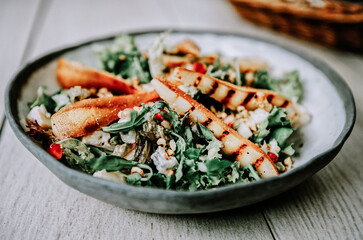 Healthy vegetarian dinner or lunch.  Salad with caramelized grilled pear, walnuts, blue cheese and pomegranate seeds.