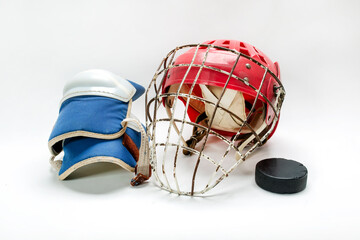 Hockey gloves,helmet and puck lay a white background isolated