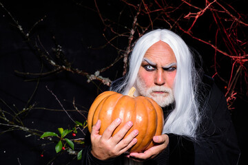 Old man with pumpkin. Horror Halloween. Scary man. Handsome man with Jack o lantern. Happy Halloween. Evil man hold Halloween pumpkin. Halloween make up.