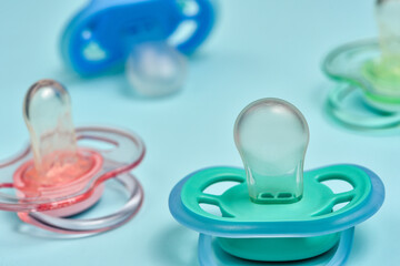 One blue plastic nipple pacifier soother on a blue background, space for text