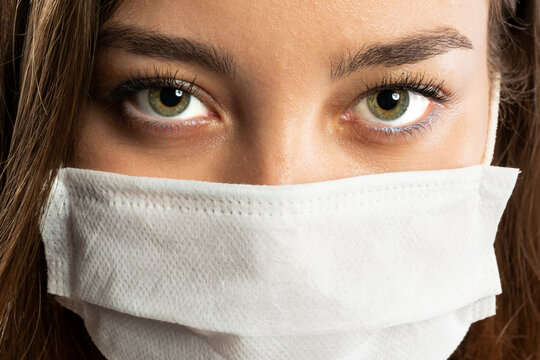 Confident doctor in protective wear and face mask wearing gloves