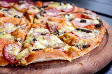 pizza lies on a wooden tray