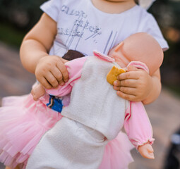 a little girl holds a doll in her hands,oy in the hands of a child close up