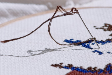 Needle stuck in the canvas with some stitches on