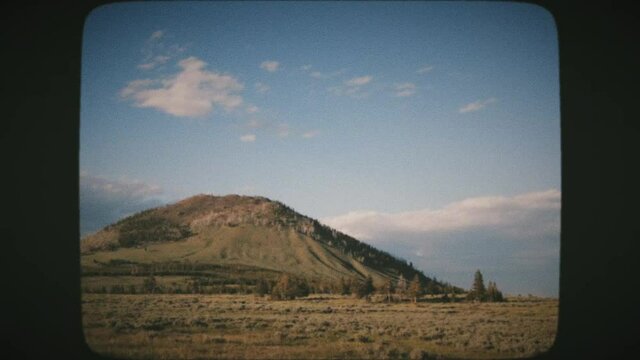 Driving through the stunning nature of Yellowstone National Park. Vintage Film Look.