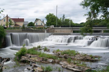 Slow motion river and waterfall in a small town
