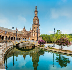 Fototapeta na wymiar Reflections in the canal in the Plaza de Espana in Seville, Spain in the early morning in summertime